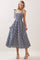woman wearing a navy and white gingham midi dress with tie straps and a smocked bodice