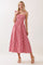 woman wearing a red and white gingham patterned maxi dress with tie straps and a fitted bodice