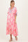 woman wearing a pink floral maternity maxi dress with tiered ruffles and a v-neckline, showing a baby bump
