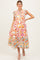woman wearing a floral patterned maternity dress with short ruffled sleeves and a tiered skirt