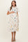 woman wearing a short sleeve floral print maternity dress and holding her baby bump