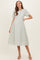 woman wearing a light green maternity dress with lace details and short flutter sleeves, styled elegantly with a flared skirt