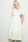woman wearing a green floral midi dress with puff sleeves and a fitted bodice