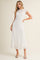 woman wearing a white short sleeve midi dress with textured pattern and a flowy skirt