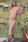 woman wearing a light pink ribbed maternity dress with a fitted silhouette and holding a woven bag, baby bump visible