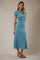 woman wearing a light blue short sleeve midi dress with a fitted bodice and flowing skirt