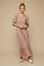 woman wearing a pink floral maxi dress with puff sleeves and ruffle hem, standing against a neutral background