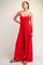 woman wearing a red sleeveless jumpsuit with wide leg and side pockets, standing with one hand on her hip