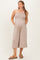 woman wearing a taupe strapless maternity jumpsuit with pockets and a flowing silhouette, showing her baby bump