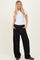 woman wearing a white short sleeve top and black wide leg trousers with pockets