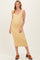 woman wearing a light yellow maternity dress with a scoop neckline and a fitted silhouette, showing her baby bump