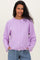 woman wearing a light purple maternity cardigan with buttons, smiling and posing with hands in pockets