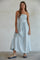 woman wearing a strapless light blue and white striped maxi dress with a fitted bodice and flowing skirt