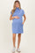 woman wearing a light blue short sleeve maternity dress with pockets and holding her baby bump