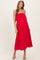 woman wearing a red strapless maternity maxi dress with ruffle detail and flowing silhouette
