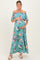woman wearing a floral off-the-shoulder maternity maxi dress and cradling her baby bump