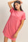 woman wearing a pink oversized t-shirt dress with a chest pocket and rolled sleeves