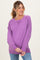 woman wearing a purple long sleeve maternity sweater with a relaxed fit and ribbed neckline