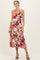 woman wearing a floral maternity dress with a halter neckline and tiered skirt, highlighting her baby bump