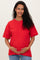 woman wearing a red short sleeve maternity t-shirt and holding her baby bump