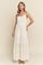 woman wearing a white tiered maxi dress with spaghetti straps and a textured design