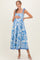 woman wearing a blue and white floral maternity maxi dress with tie straps and holding her baby bump