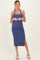woman wearing a navy blue ribbed maternity halter dress with a side slit and a baby bump visible
