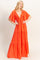 woman wearing a vibrant orange maxi dress with a deep v-neck and flutter sleeves