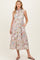 woman wearing a floral print sleeveless maternity dress with pockets and a collared neckline