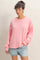 woman wearing a pink oversized long sleeve sweatshirt and denim shorts