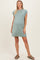 woman wearing a sage green maternity dress with short sleeves and a relaxed fit, showing her baby bump