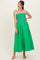 woman wearing a bright green maternity dress with a smocked bodice and adjustable straps