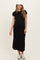 woman wearing a black maternity dress with short sleeves and white trim, standing and showing her baby bump