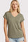 woman wearing an olive green short sleeve v-neck t-shirt and distressed denim shorts