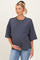 woman wearing a dark gray oversized maternity sweatshirt and holding her baby bump