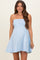 woman wearing a light blue striped strapless maternity dress, showing her baby bump