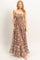 woman wearing a brown floral maxi dress with a smocked bodice and ruffle hem