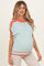 woman wearing a light blue maternity sweater with orange and coral accents and a visible baby bump