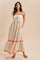 woman wearing a white floral embroidered maxi dress with ruffled sleeves and a tiered hemline