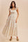 woman wearing a floral maxi dress with smocked bodice and tiered skirt, standing against a neutral background
