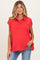 woman wearing a red sleeveless maternity polo shirt and distressed jeans