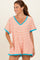 woman wearing a striped orange and white oversized v-neck tee with turquoise trim and pockets