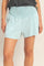woman wearing light blue relaxed fit shorts with smocked waistband and side pockets