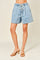 woman wearing light blue denim shorts with a drawstring waist and side pockets