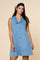 woman wearing a light blue denim sleeveless dress with a collar and buttons down the front