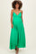 woman wearing a green maternity maxi dress with a deep v-neckline and a flowing silhouette, showcasing her baby bump