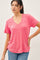 woman wearing a pink v-neck short sleeve t-shirt paired with blue jeans