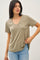woman wearing an olive green short sleeve v-neck t-shirt paired with light blue jeans