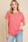 woman wearing a coral oversized t-shirt with rolled sleeves and light blue jeans
