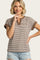 woman wearing a brown and cream striped short sleeve top with a henley neckline and rolled cuffs